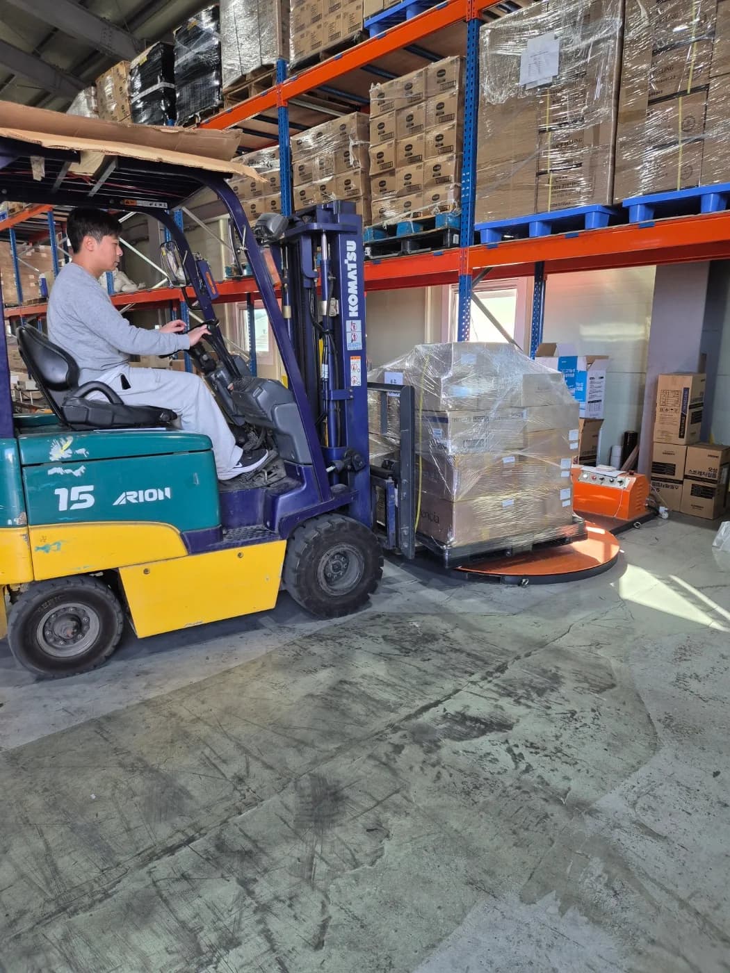 Forklift moving wrapped pallets in the warehouse